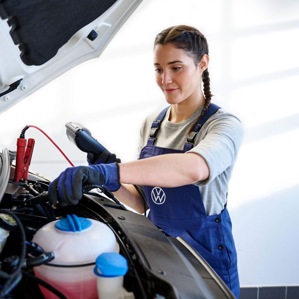 Eine Volkswagen Technikerin überprüft eine Starterbatterie