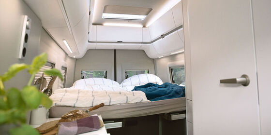 Fotoja tregon shtratin tek Grand California 680 me ndriçim komod ambienti.